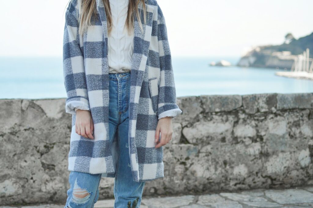Person im Mantel auf der Straße als Inspiration für Herbstlooks mit Karomuster