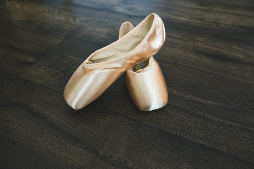 Goldene Schuhe auf Holzboden als Inspiration für Metallic-Töne bei Ballerinas und Loafern