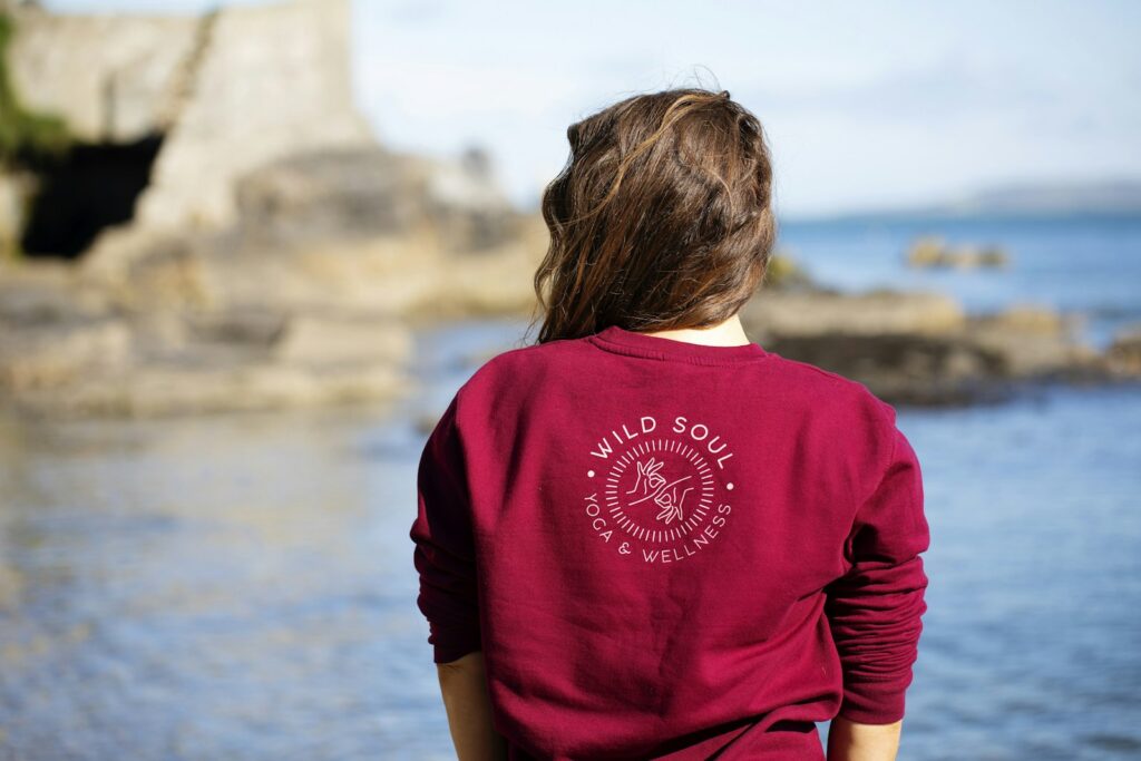 Frau in burgunderrotem Pullover am Meer