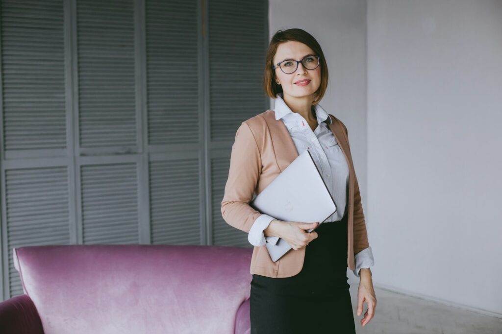 Frau im Business-Anzug mit Laptop als Inspiration für Business Casual im Büro