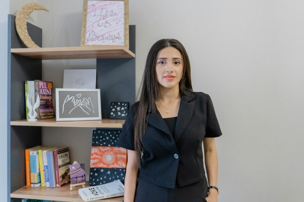 Frau im schwarzen Anzug am Bücherregal, formeller als klassisches Business Casual