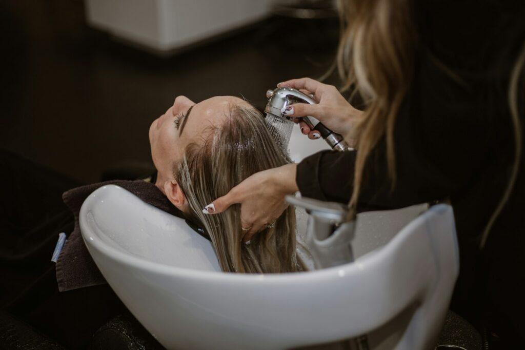 Frau beim Friseur lässt sich zu aktuellen Haarfarben-Trends beraten
