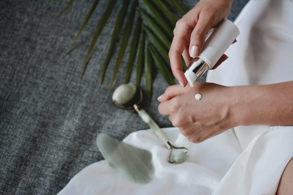 Jaderoller und Gua-Sha-Stein mit Lotion als Ritual zur Hautpflege im Herbst