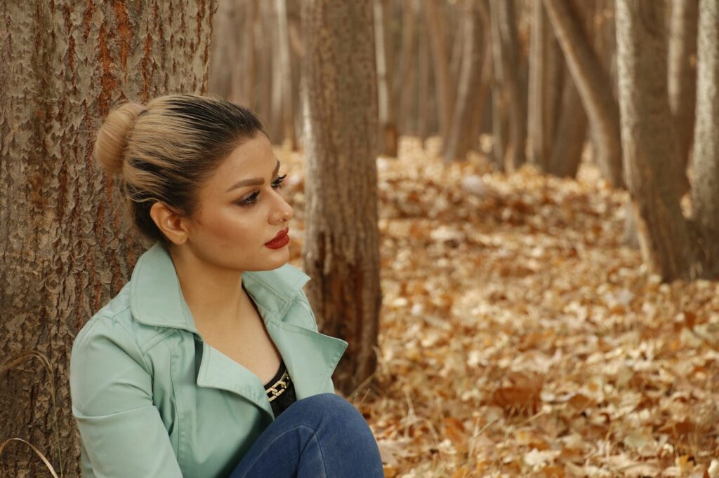 Herbstlook im Stil der Herbsttrends 2026: Frau neben einem Baum