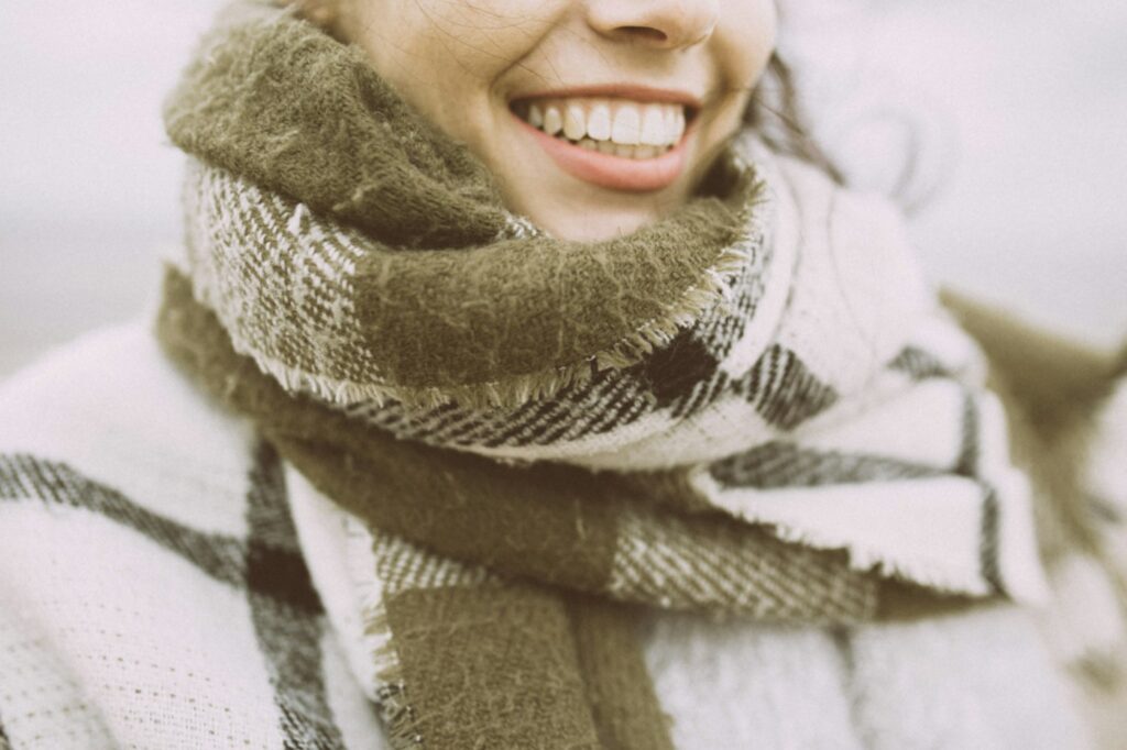 Frau mit schwarz-weißem Schal als Accessoire für Layering im Winter
