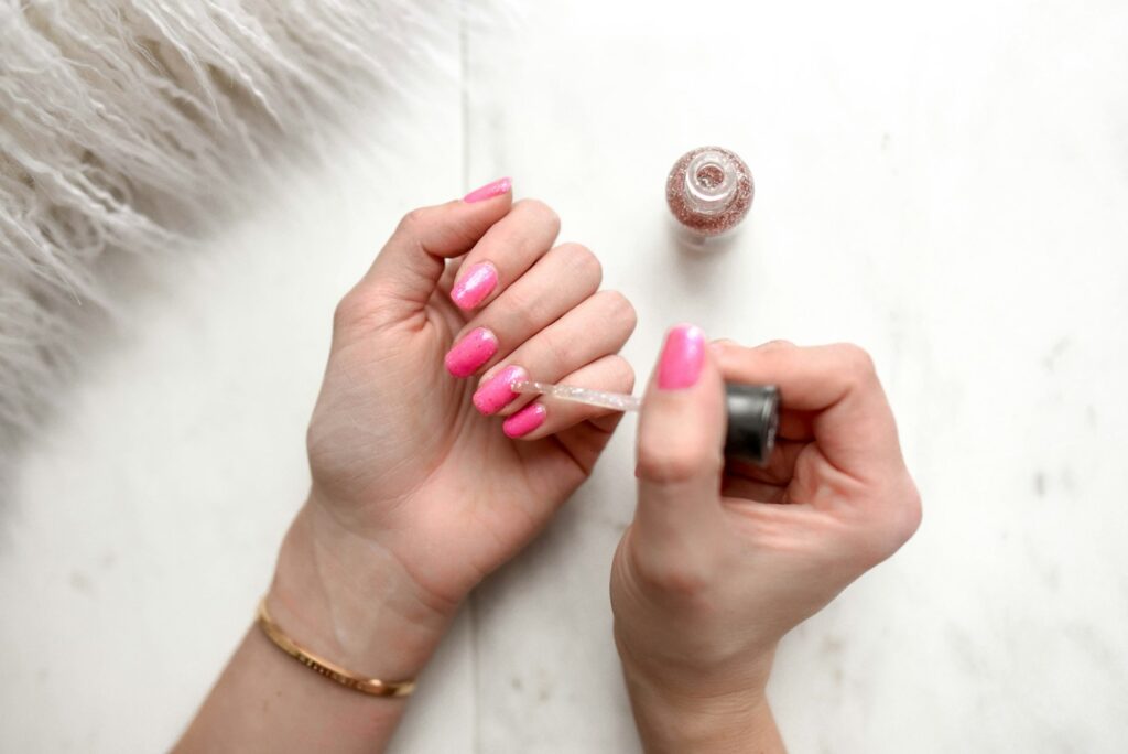 Glitzernder Nagellack auf rosa Nägeln
