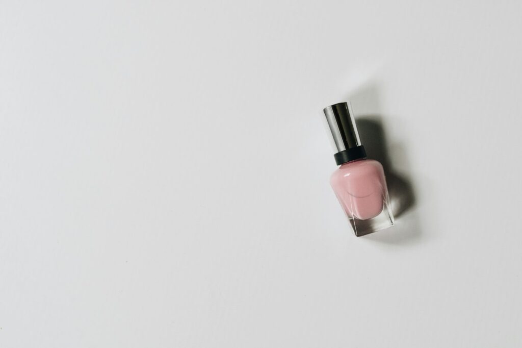 Rosa Nagellackflasche als zarte Alternative zu dunklen Nagellack-Farben