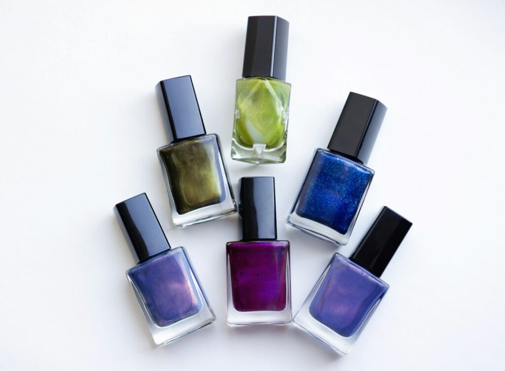 Fünf Fläschchen Nagellack in verschiedenen Nagellack-Farben nebeneinander