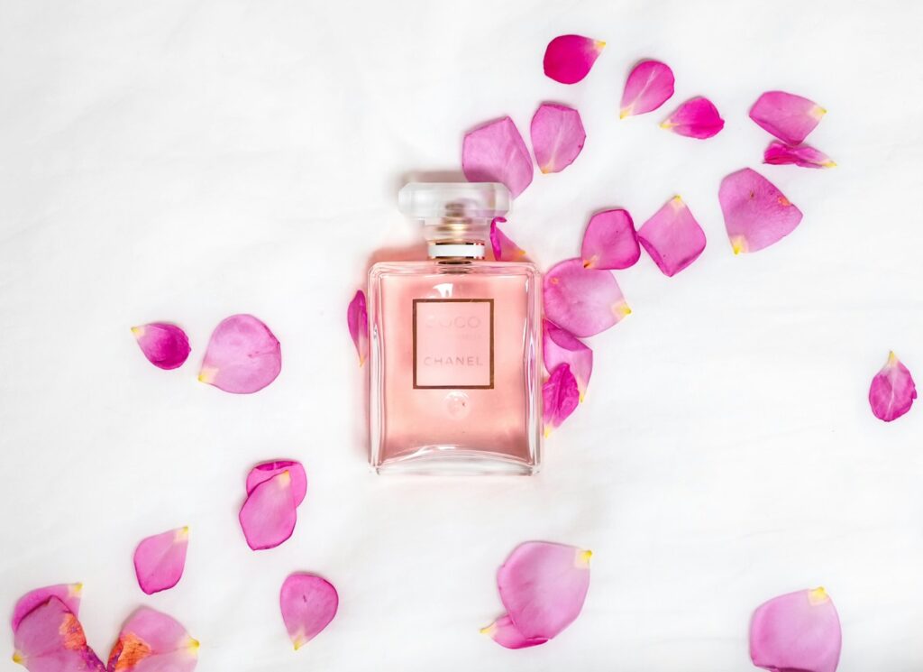 Parfum finden: Flakon zwischen rosa Blütenblättern