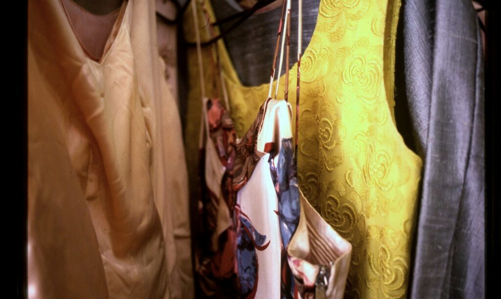 Bunte Kleidung und Schals im Laden, Auswahl an Vintage-Designermode und Accessoires