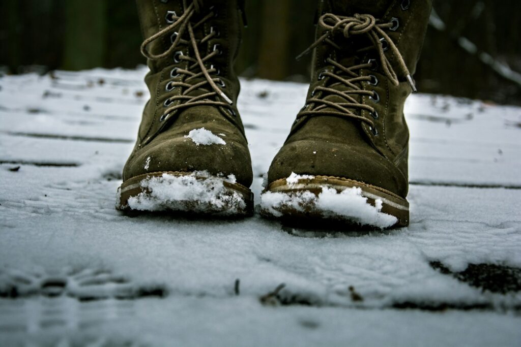 Braune Lederstiefel im Schnee